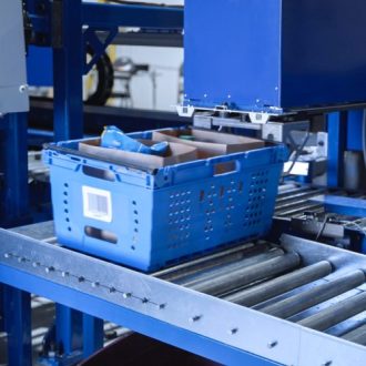 Bac d’épicerie bleu positionné sous un module vertical de stockage et de récupération Storix.